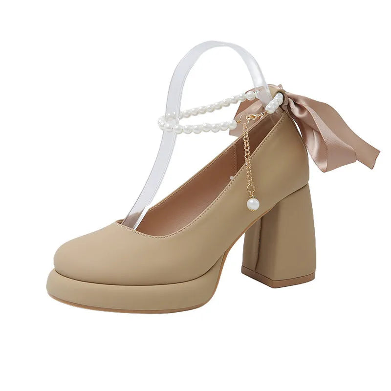 Women's beige Mary Jane shoes with chunky heel and ankle-strap buckle on a neutral background