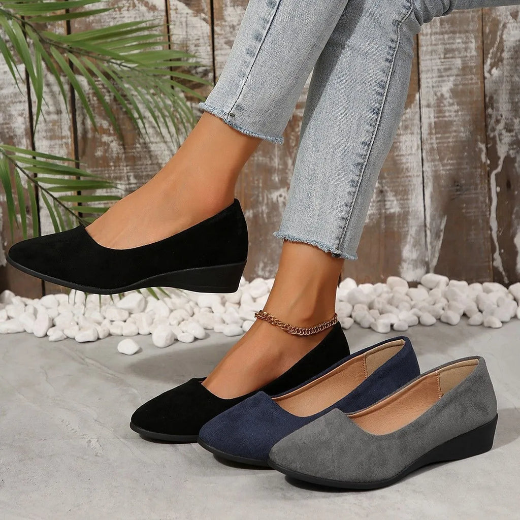 Women's black pointed toe wedge pumps with shallow mouth opening and low rubber wedge heel