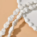 Assorted small ceramic torch beads in multiple colours on a white background.