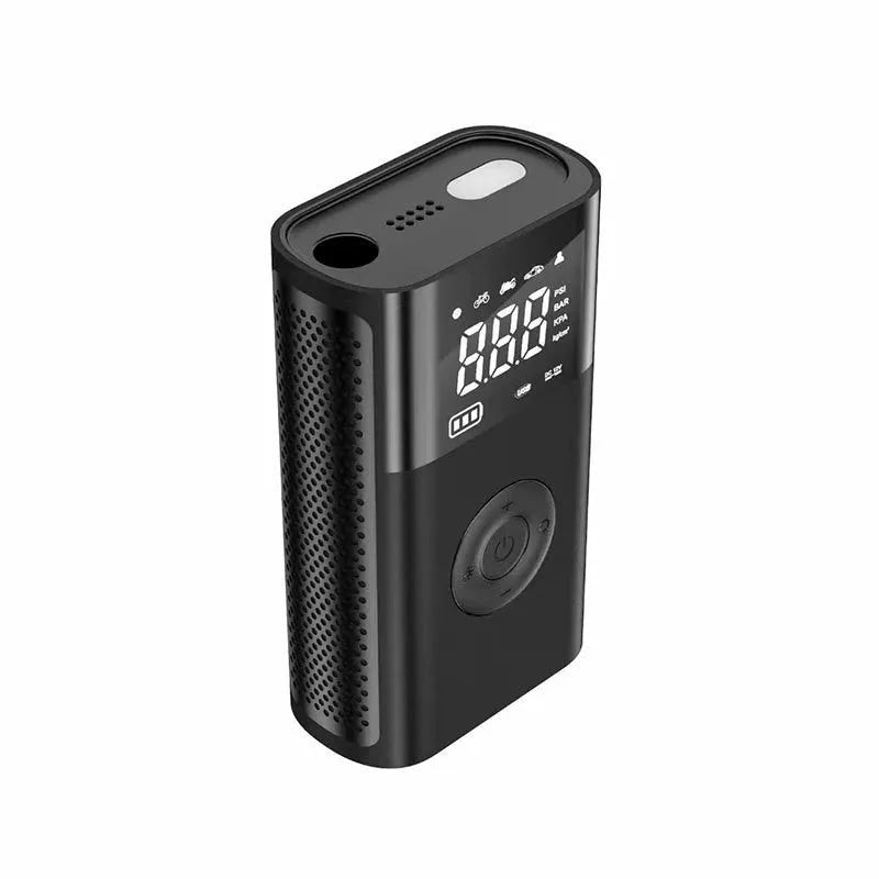Handheld wireless digital tyre inflator with display screen, LED light, and multiple nozzle adaptors on a table.