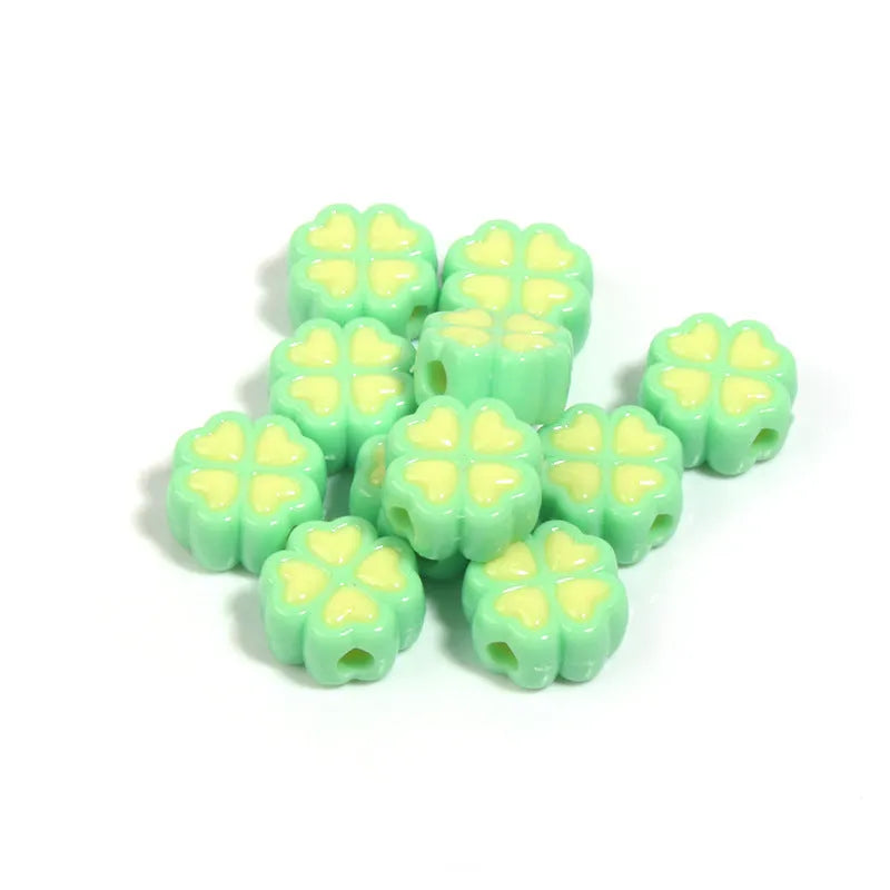 A selection of 15mm frosted acrylic beads showing a raised cartoon love and four-leaf clover pattern in various colours.