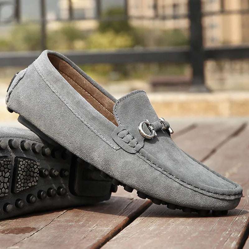 Men's black cowhide leather slip-on shoes with square toe and visible stitching on a rubber sole.