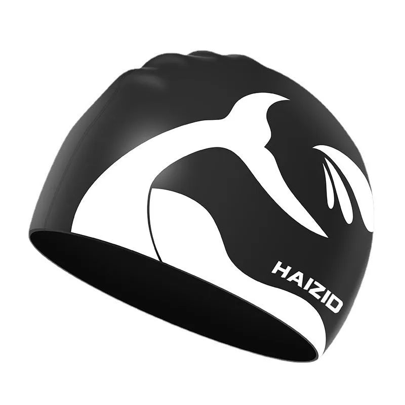 Close-up of a grey silicone swim cap with a whale tail pattern and integrated ear protectors.