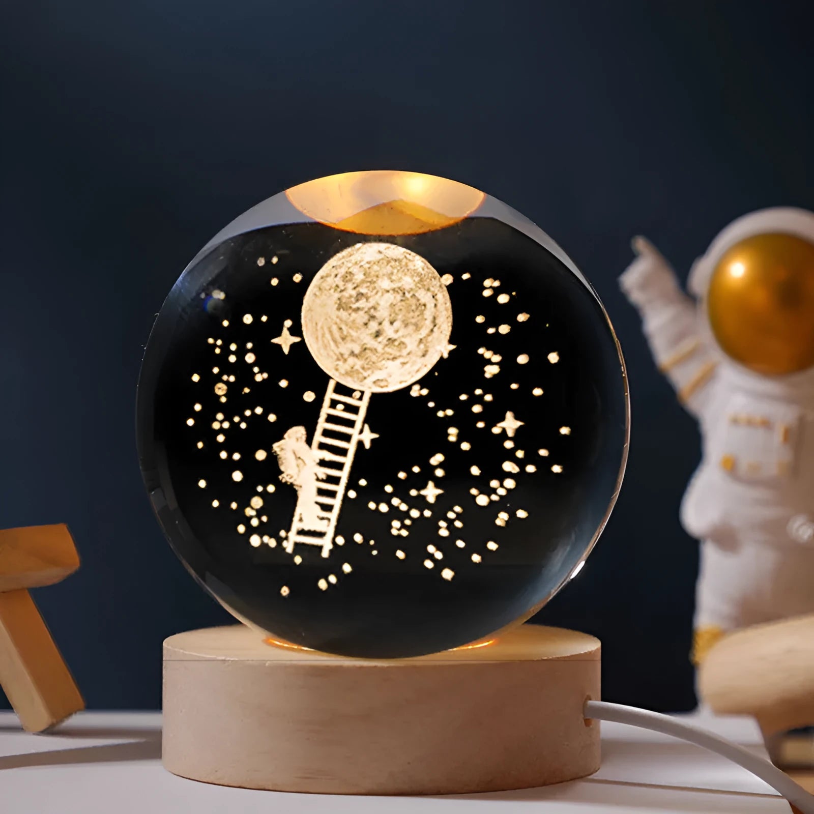 Illuminated crystal ball night light on a wooden base for desktop decoration.