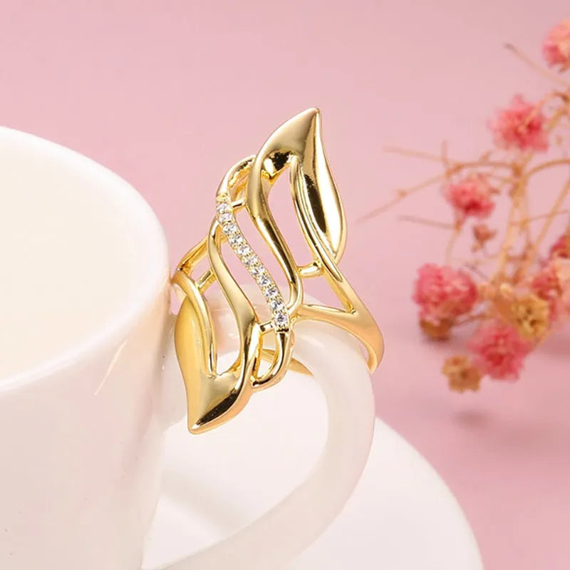 Gold copper women's ring with exaggerated curve silhouette and zircon sparkle on finger