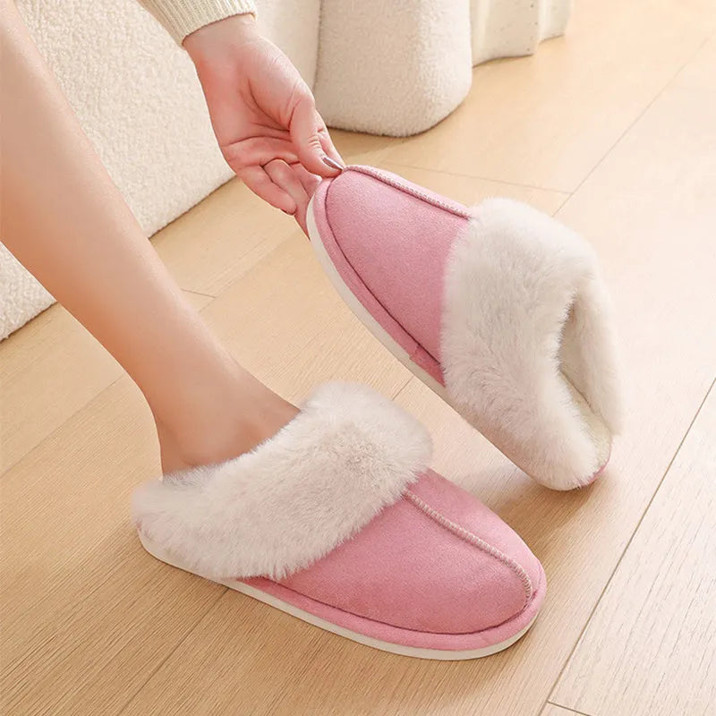 A pair of brown plush winter slippers with a round toe, flat heel, and non-slip PVC sole.