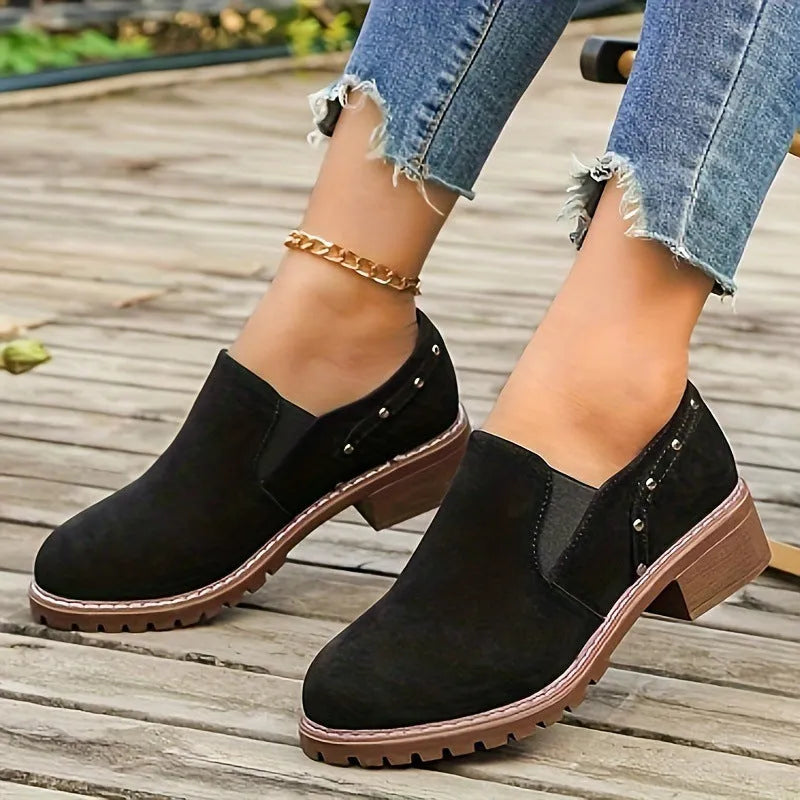 Women's light brown suede ankle boots with a low thick heel and elastic band fastening.