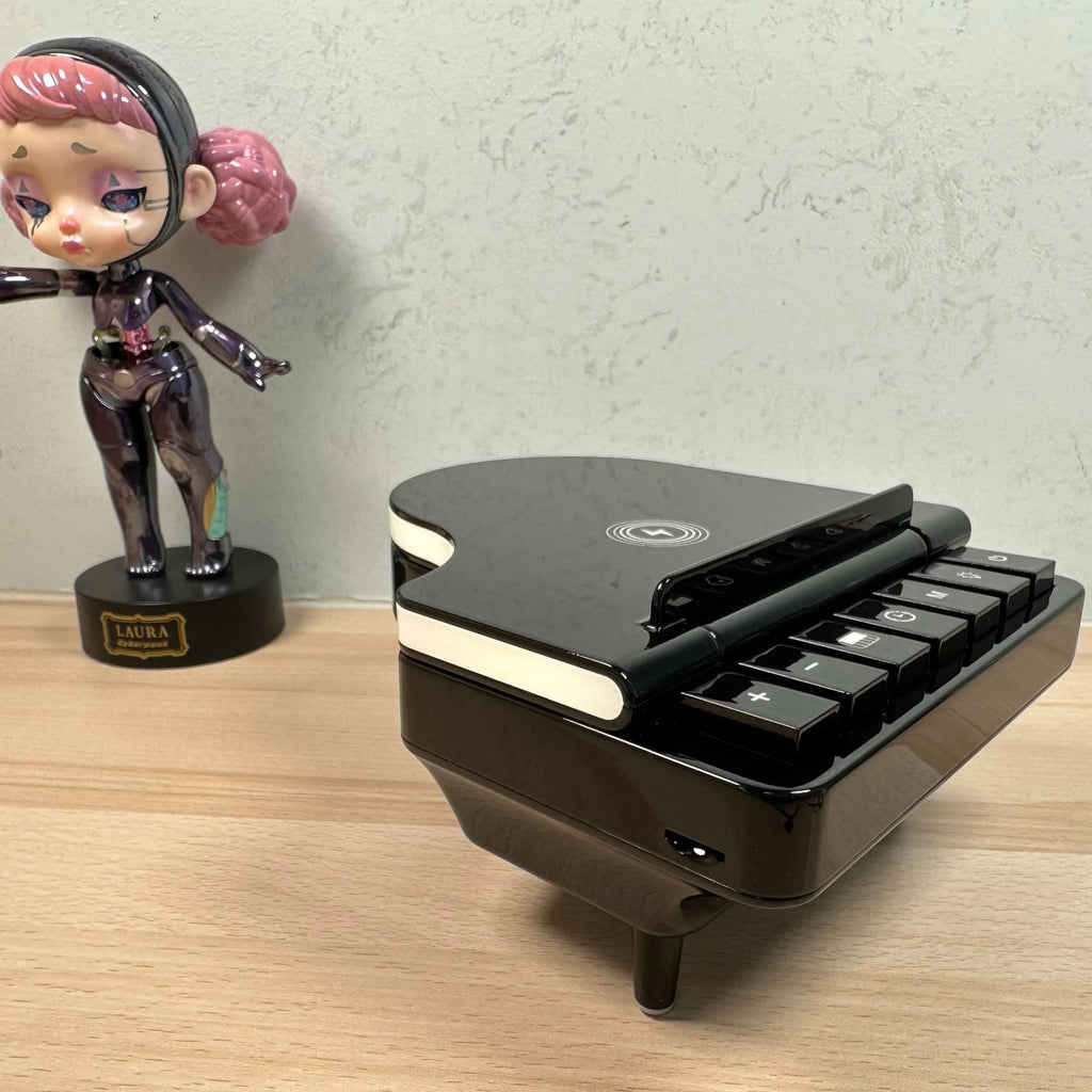 Black multi-function Bluetooth speaker with wireless charger and phone holder on a desk