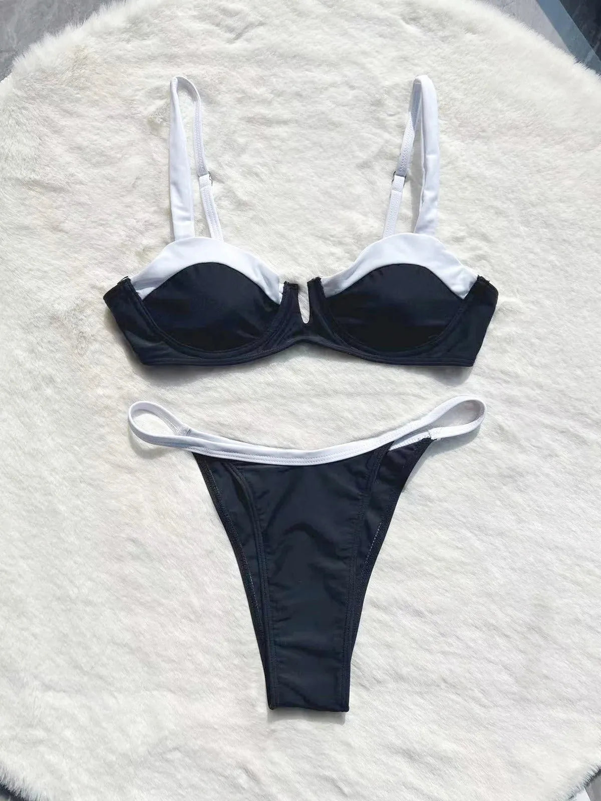 Women's black low waist bikini swimsuit with stitching split detail on mannequin