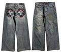 Grey washed-out denim jeans on a man, showing wide-leg straight cut and mid-waist fit.