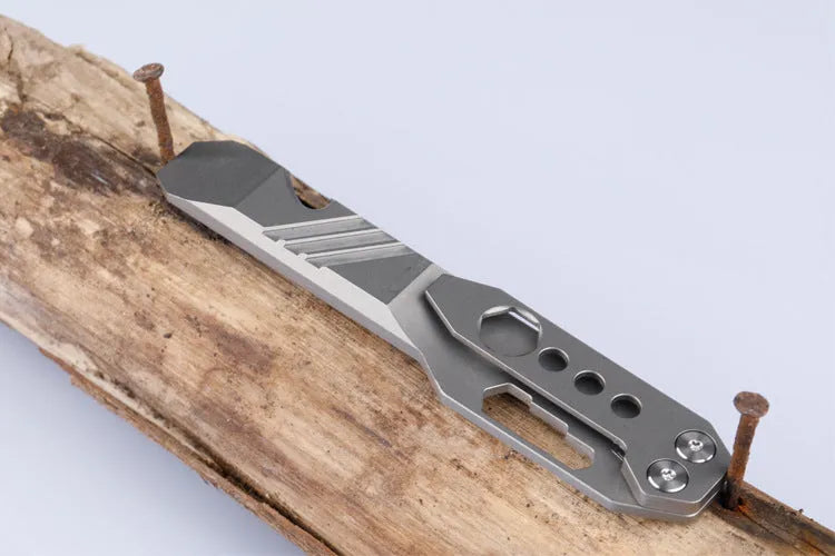 Titanium alloy multi-function crowbar tool with integrated bottle opener in gun grey or stone wash finish.