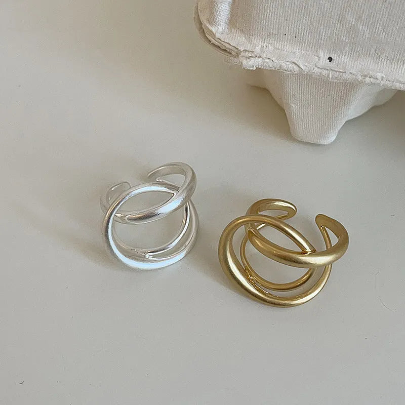 Geometric open ring with interlaced design in matte gold metal finish