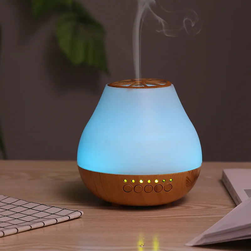 USB ultrasonic aroma diffuser with wood grain finish and colourful light on a wooden desk