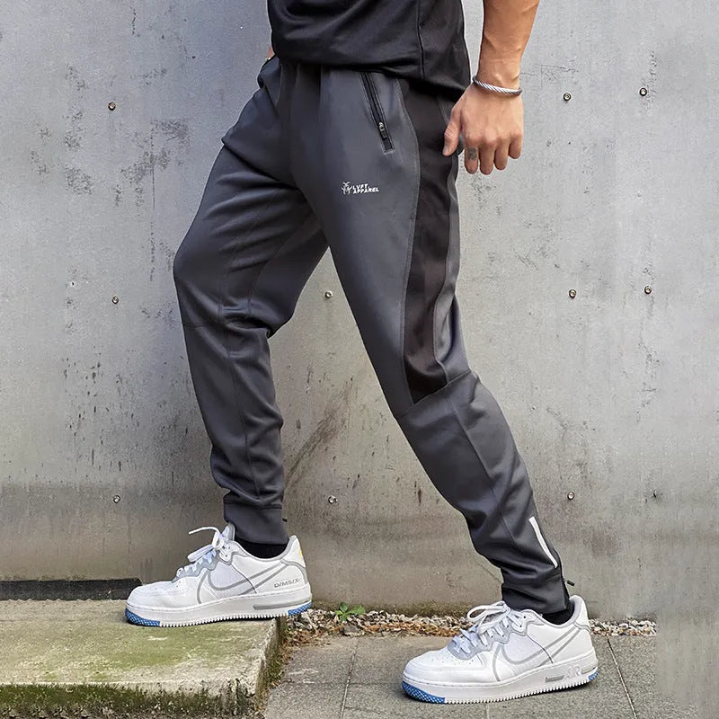 Men's deep gray stretch polyester sweatpants with panel zip pockets, side view
