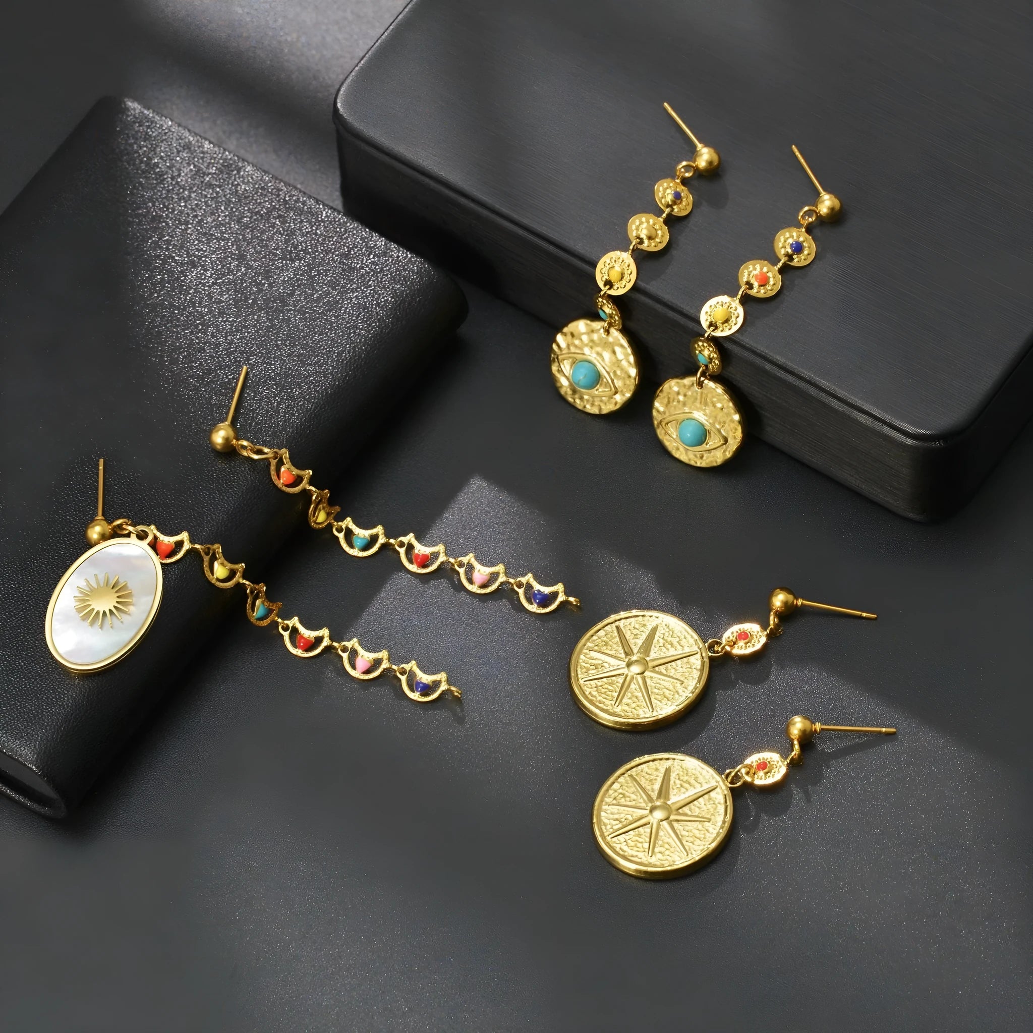 Stainless steel geometric drop earrings in Eight Awn Star, Eye, and Shell Sun designs.