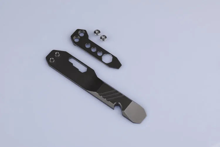 Titanium alloy multi-function crowbar tool with integrated bottle opener in gun grey or stone wash finish.