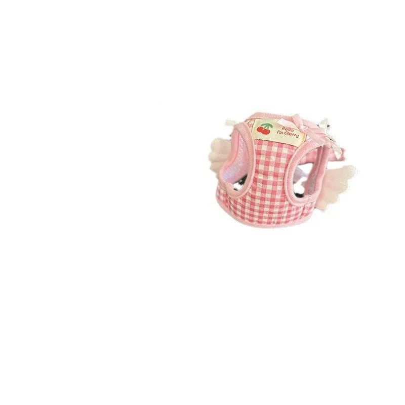 Small dog wearing pink cotton chest-back harness with hand holding rope attached