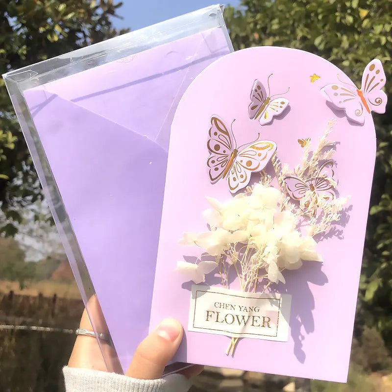 Handmade 3D boxed greeting card with butterfly shape, hot stamping, and artificial flowers on coated paper.