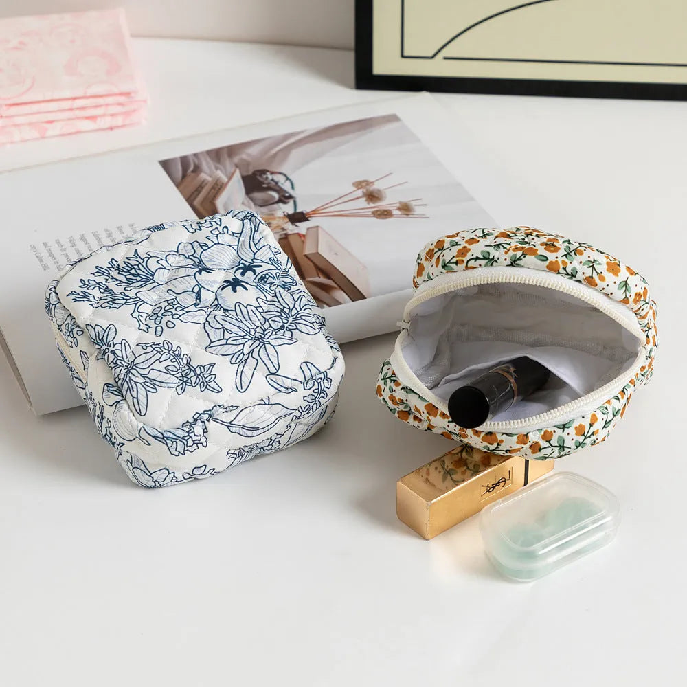 Small floral polyester key storage wallet with sewing thread detail in multiple colour patterns.