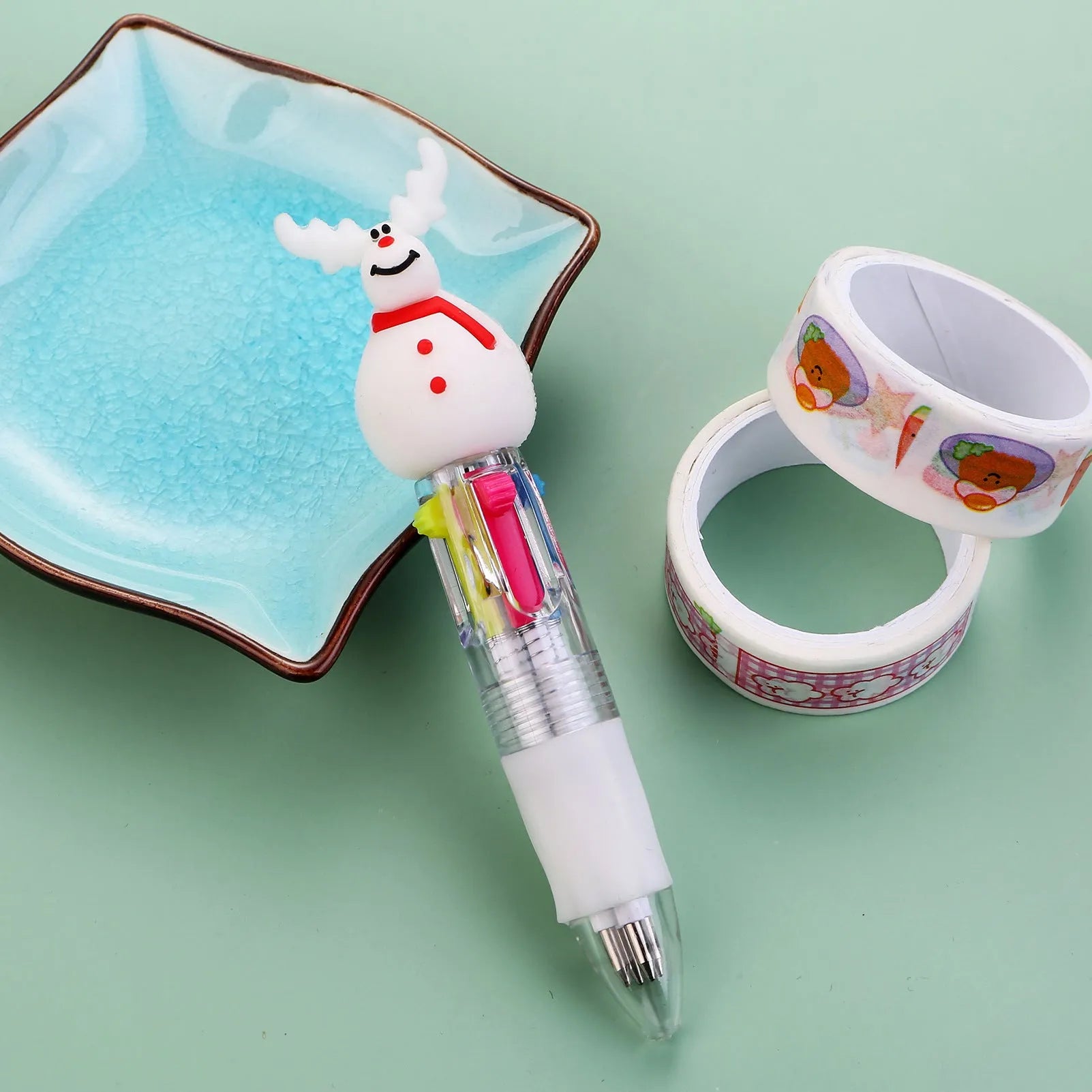 11cm long Christmas-themed four-colour ballpoint pen showing festive designs like reindeer and trees.
