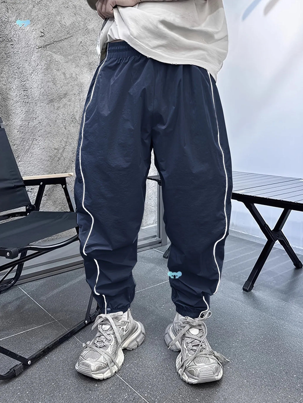 Man wearing blue cropped bamboo fibre sports trousers with a loose, elasticated fit.