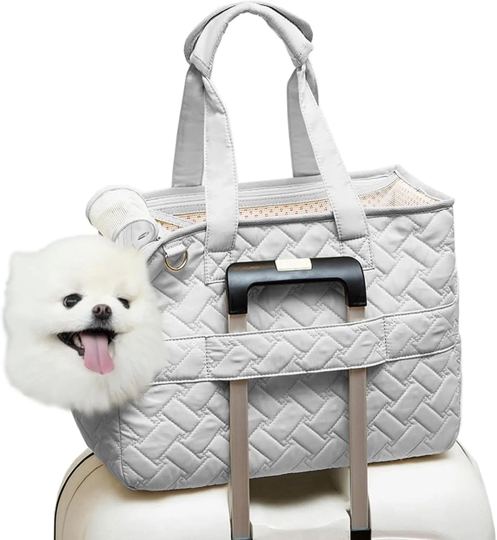 Grey pet carrier handbag with mesh panels and shoulder strap on a table