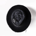 Handmade wool skull hat with conical crown and black and white embroidery for Halloween costumes.