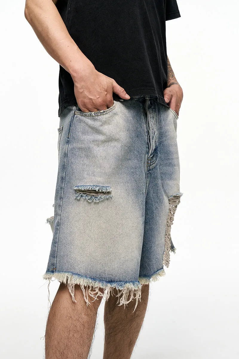 Light blue men's baggy denim shorts with a washed finish and zipper fly on a mid waist.