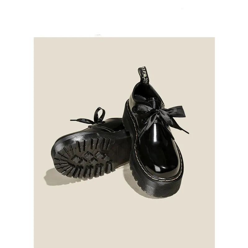 Women's thick-soled black shoes with cross strap and ribbon detail, lace-up closure