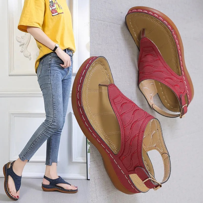 Women's red wedge heel sandals with an adjustable buckle strap on a white background