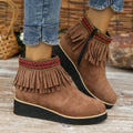 Women's dark brown suede wedge ankle boots with side zipper and tassel detail on a thick rubber sole.
