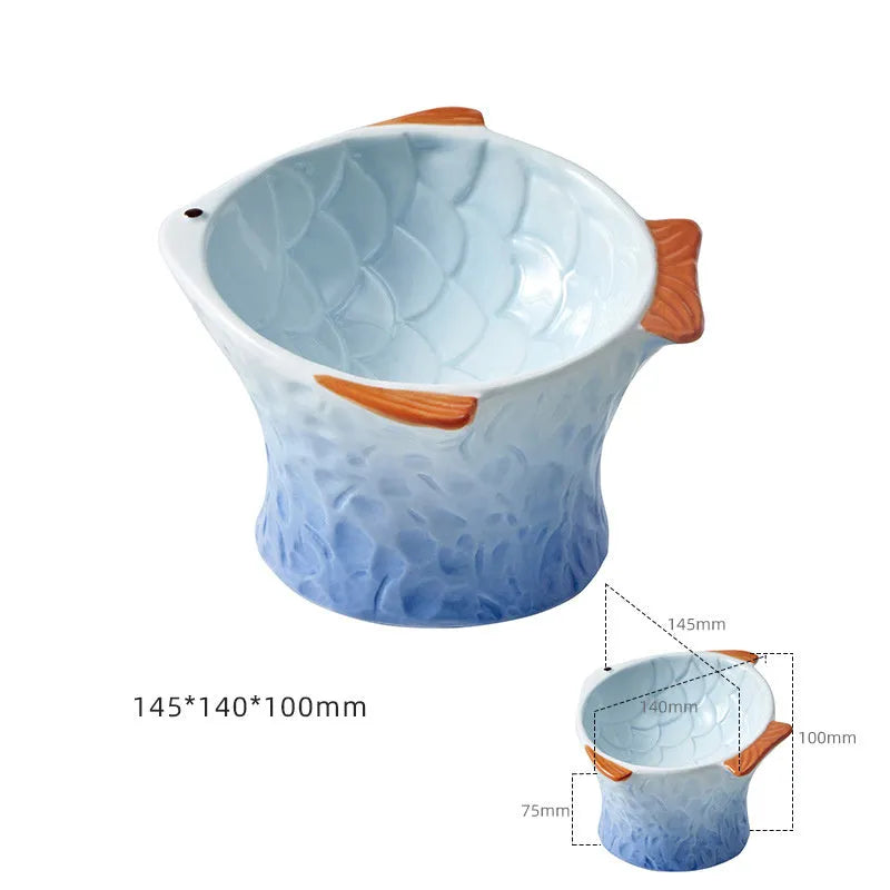 Set of four blue fish-shaped ceramic cat bowls with a tilted angle on a flat surface.