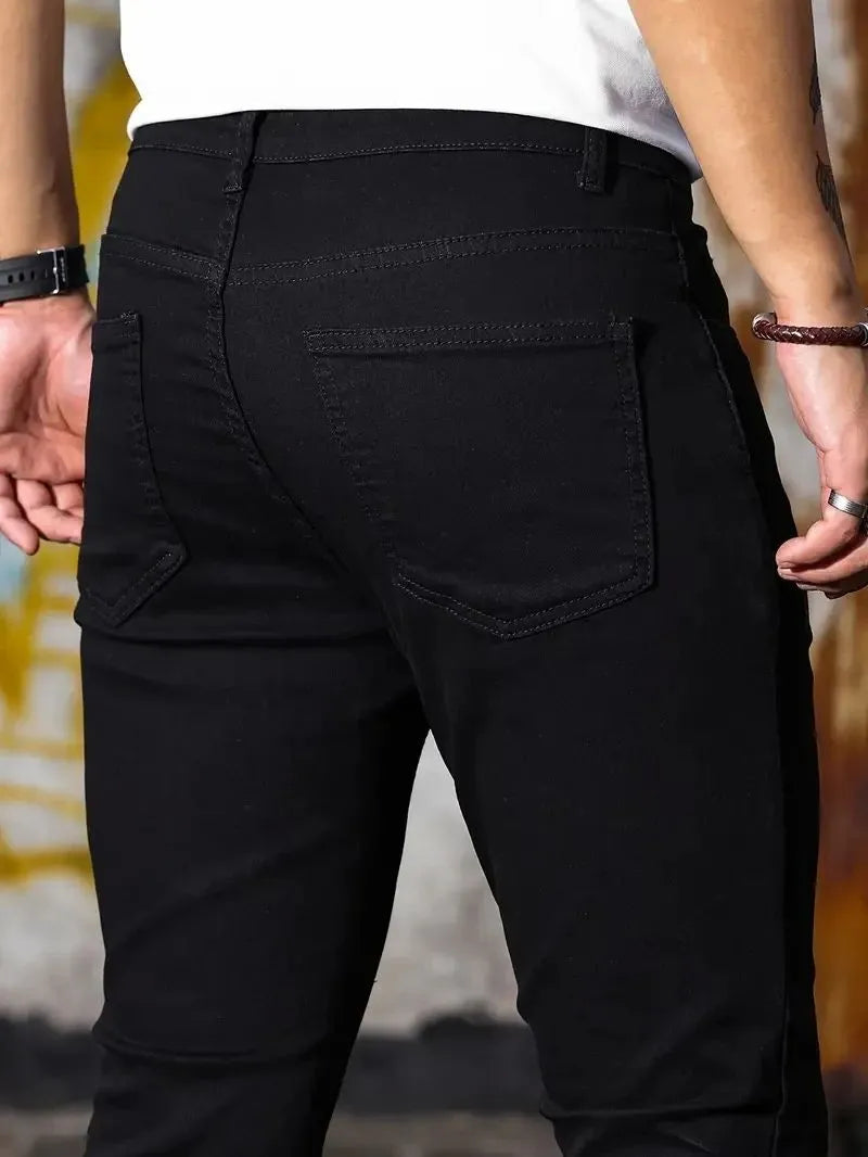 Man wearing retro wash stretch slim fit five-quarter length jeans in blue with zipper and five-pocket design