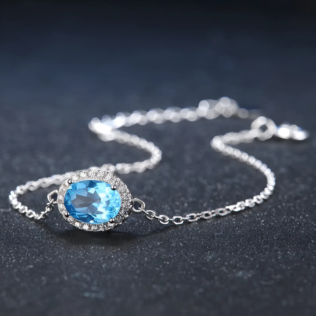 Geometric 925 sterling silver jewellery set with blue topaz stones, showing necklace, earrings, ring, and pendant.