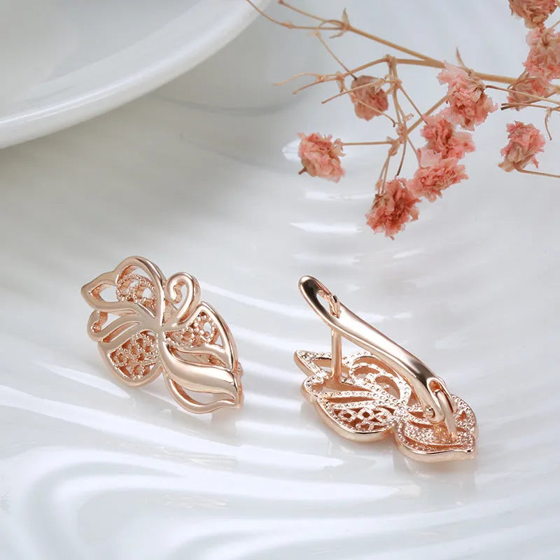 Pair of rose gold hollow carved geometric earrings with rhinestone accents on copper base