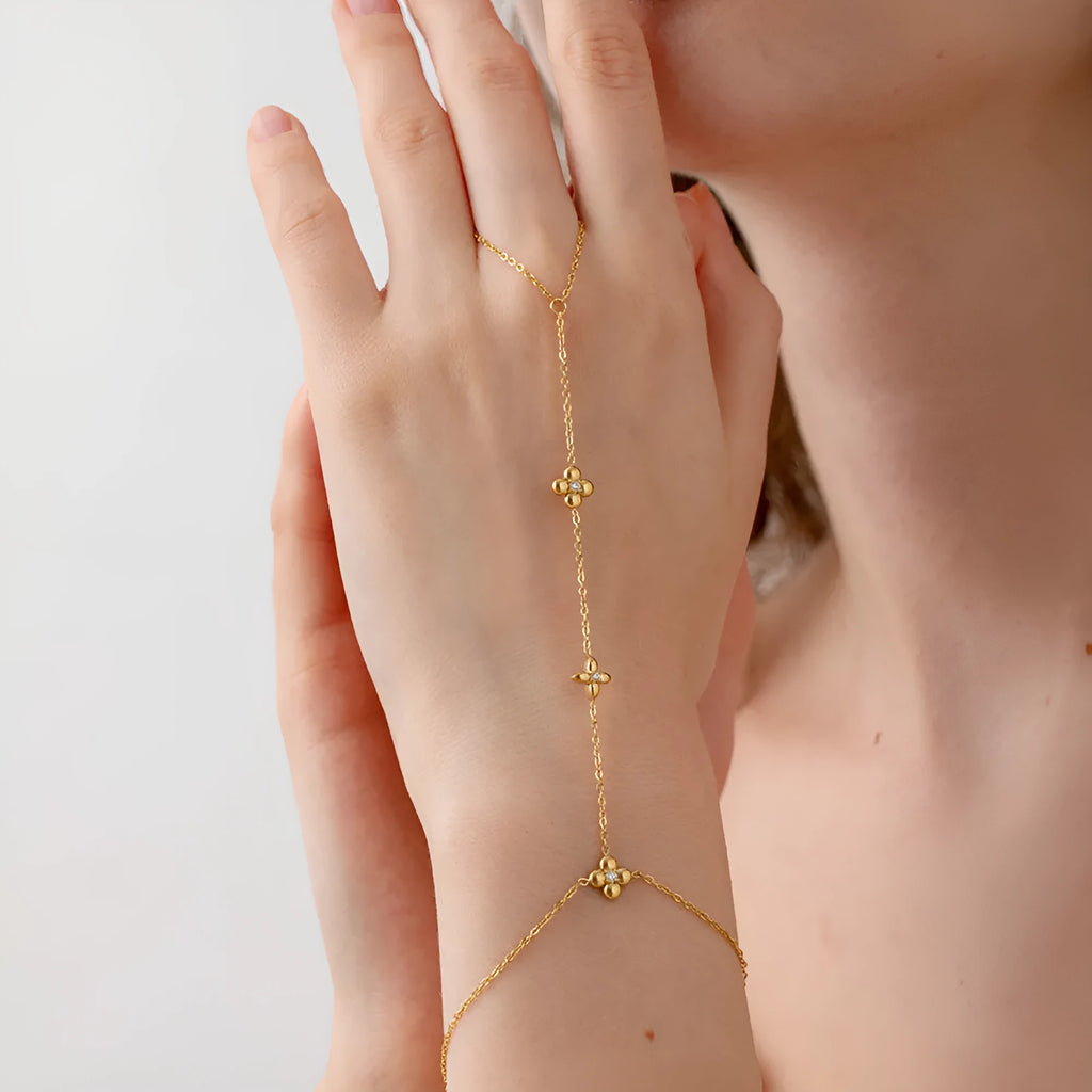 Gold stainless steel bracelet with eight pointed star and flower charms