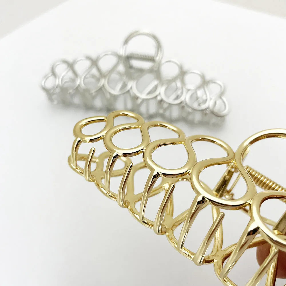 Minimalist large hair clip with electroplated finish and tassel detail.