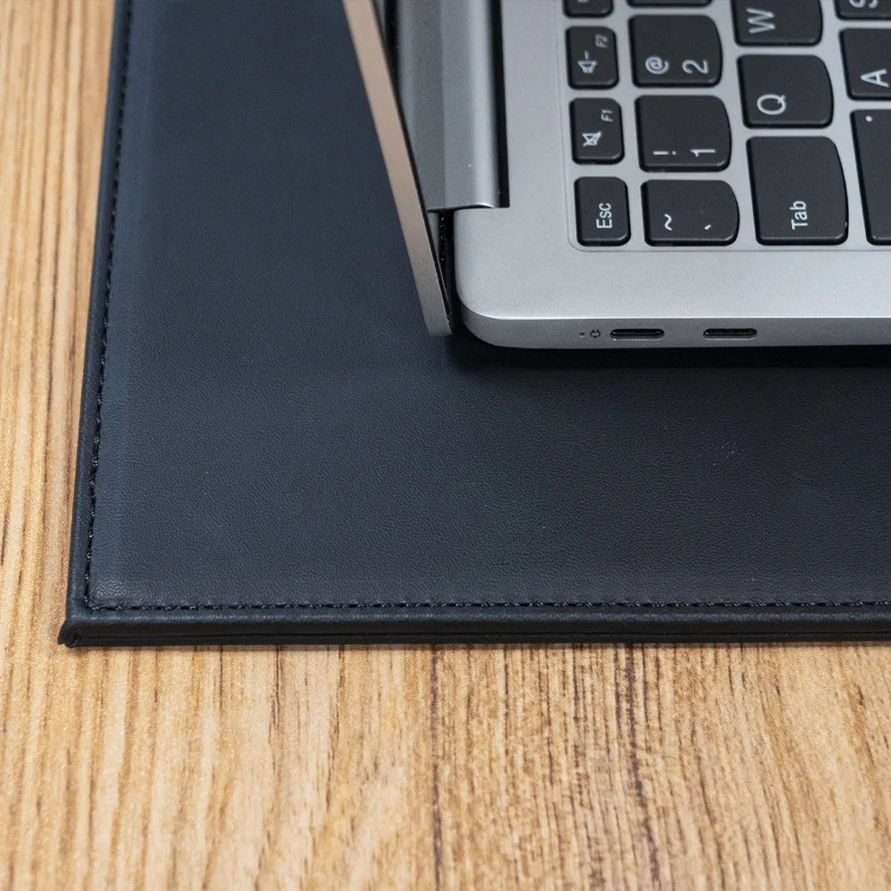 A4 anti-radiation laptop cooling pad with waterproof PU leather cover in various colours on a desk.