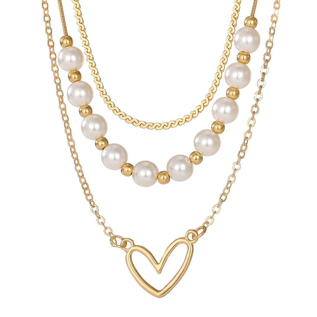 Vintage gold necklace with heart pendant on adjustable pearl chain, showing electroplated finish and love motifs