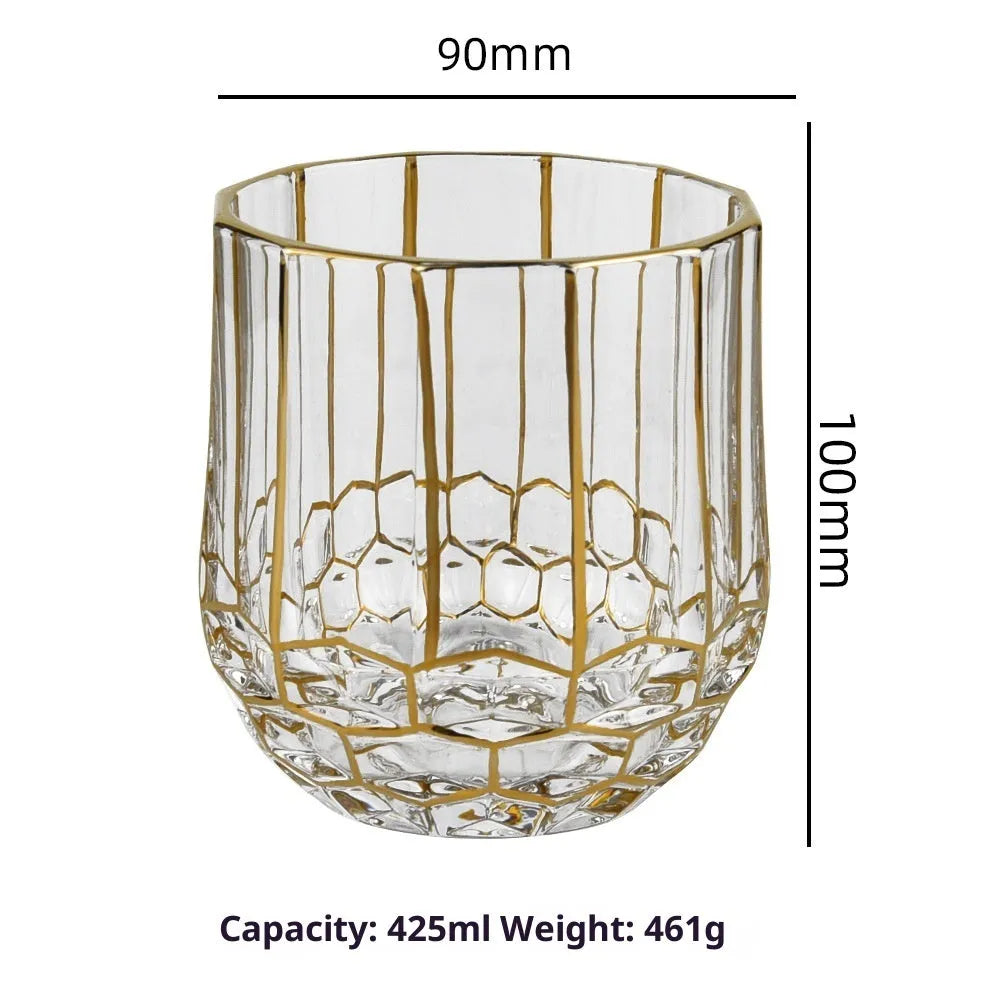 Crystal glass whiskey shot glass with solid gold finish on a bar counter