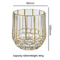 Crystal glass whiskey shot glass with solid gold finish on a bar counter
