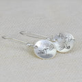 Silver zinc alloy women's earrings with bird and leaf design in circular retro style