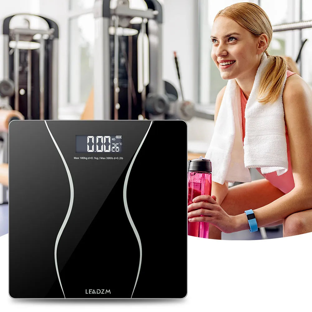 Black digital electronic bathroom scale on a tiled floor showing a weight reading.