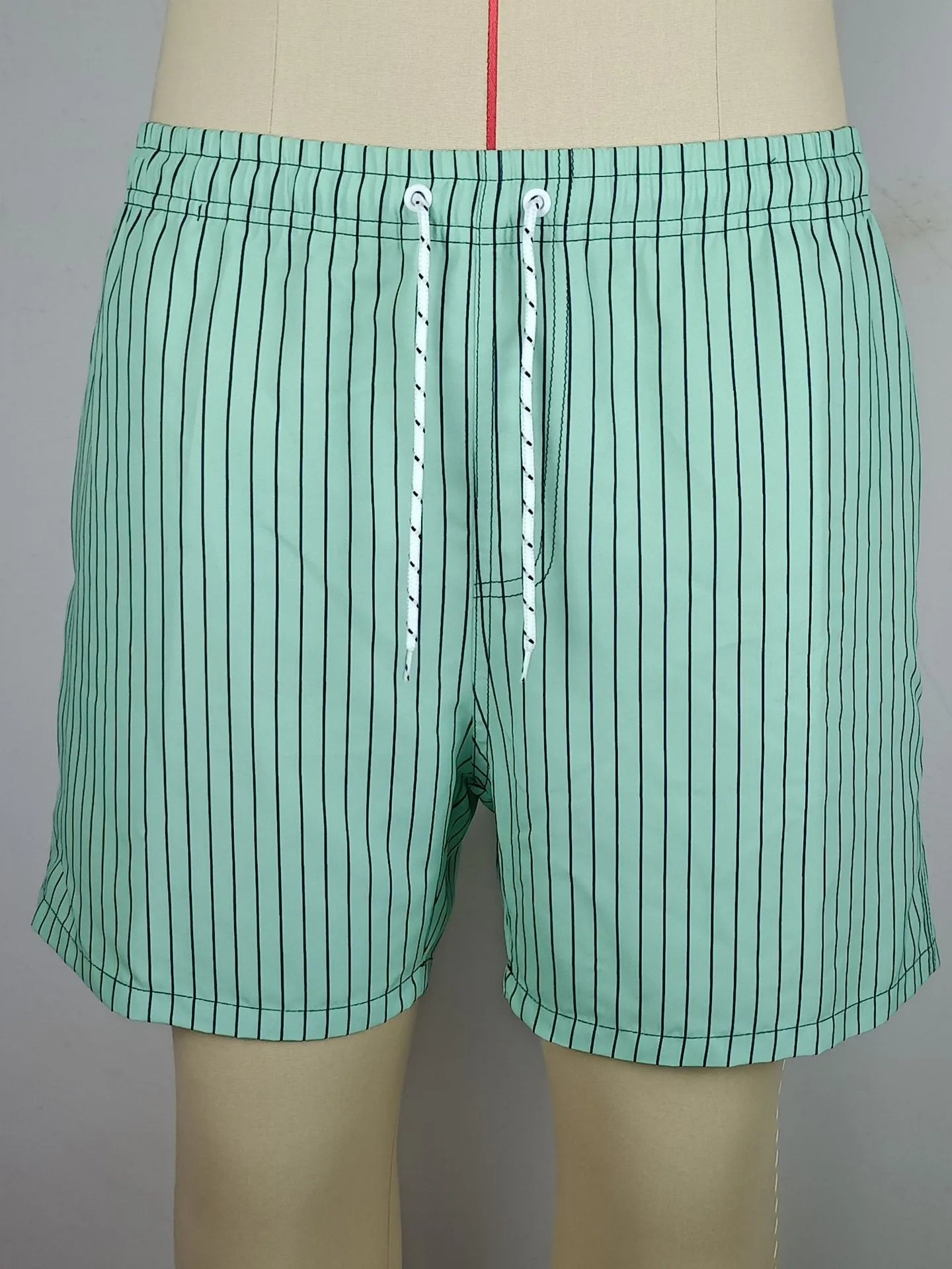 Striped triangle lining beach shorts in navy blue, grey, khaki and light blue colours with straight leg opening
