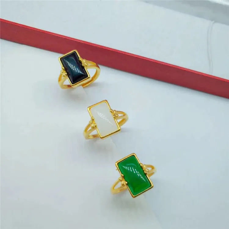 Adjustable gold-plated brass ring with a black gemstone inlay on a model's hand.
