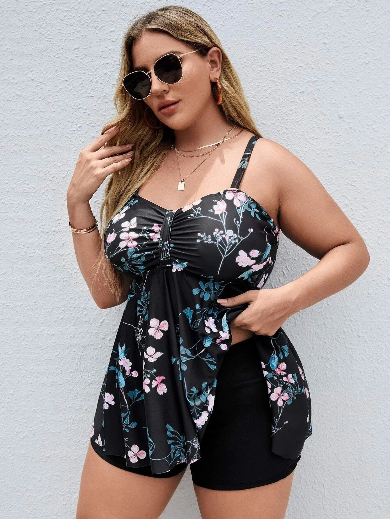 Women's floral print one-piece swimsuit on a hanger, showing split colour pattern.