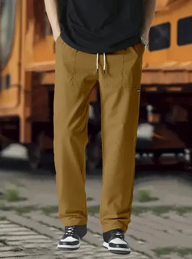 Man wearing lightweight grey polyester trousers, showcasing fit and casual style for spring or autumn.