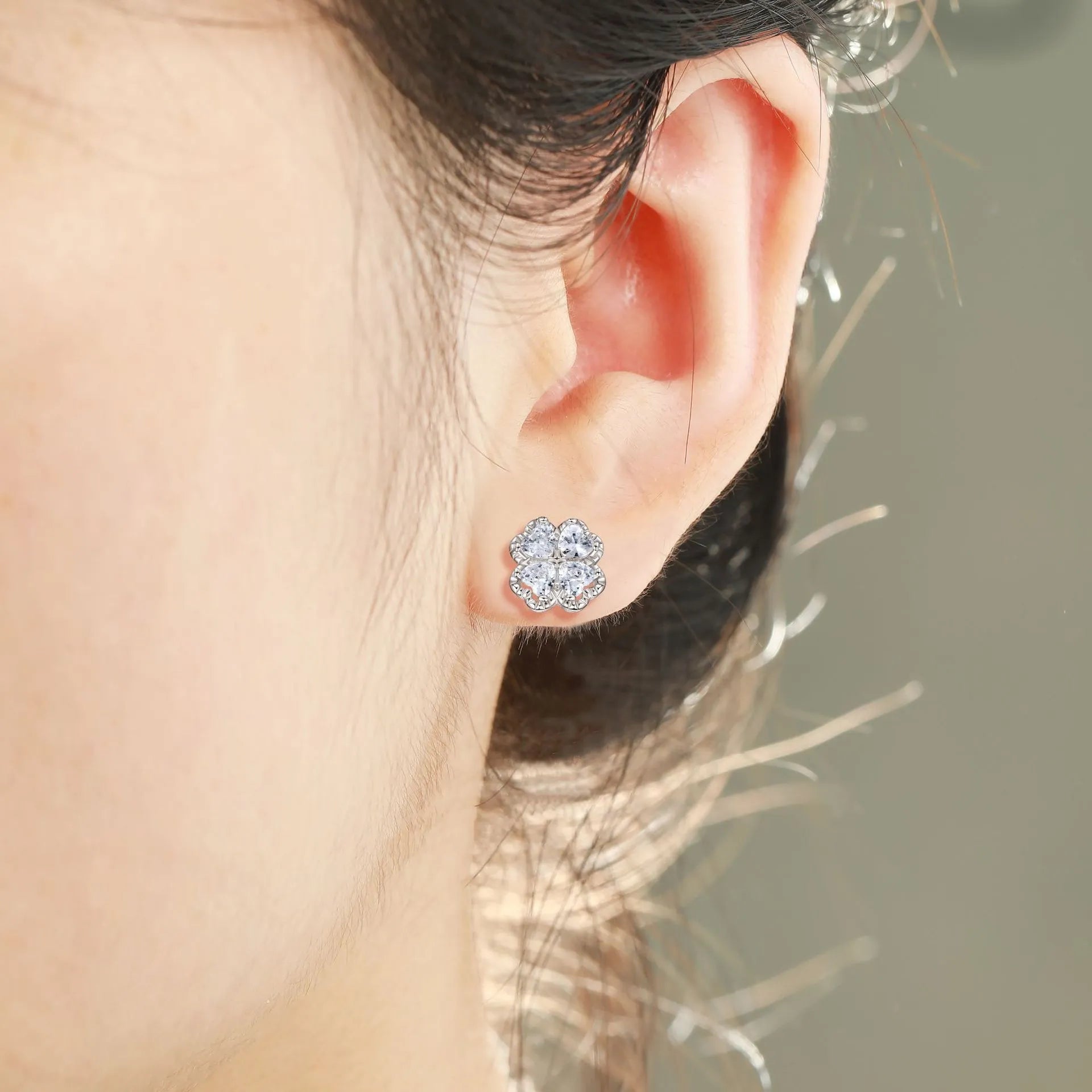 Pair of heart-shaped sterling silver earrings with four-leaf clover design and white gold colour finish.