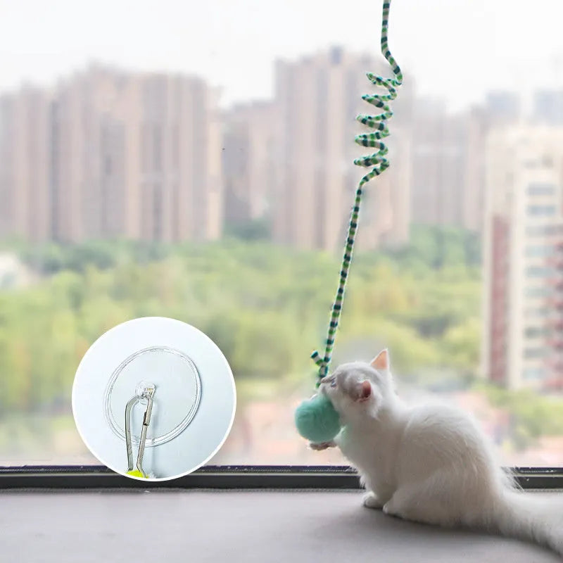 Spring cat toy with bell stick and inflatable ball hanging from door with suction cup