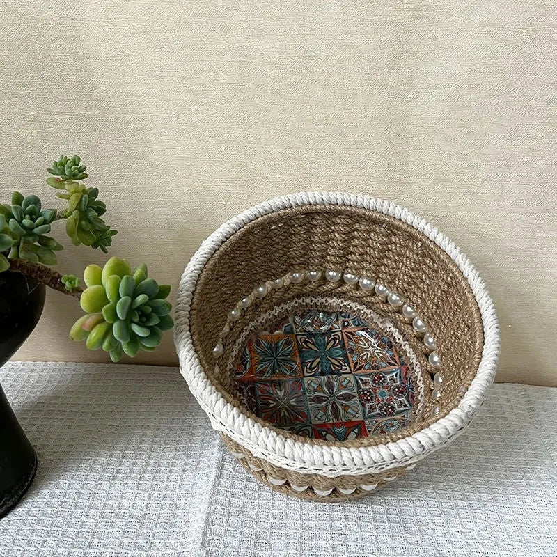 Rattan hand woven cylinder storage basket in green on desktop holding snacks and keys